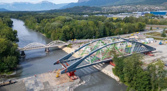La structure du nouveau pont, d’environ 2 000 tonnes, a été posée sur ses appuis définitifs lors d’une opération de ripage réalisée grâce à trois engins porteurs et à la constitution d’une plateforme dans la rivière. 